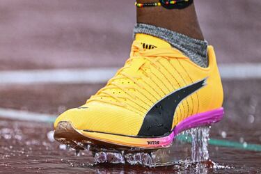 La atleta jamaiquina Nickisha Pryce se ve con sus zapatillas bajo la lluvia en la pista antes de competir en la final femenina de 400 metros durante el Campeonato Mundial de Atletismo en Tokio. 