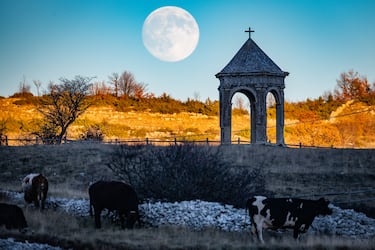 La luna llena visible tras el monumento Palco della Rimembranza, se observa en Terranera (Rocca di Mezzo), Italia.