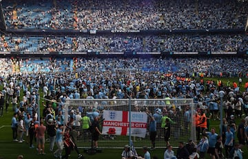 Los seguidores del Manchester City invaden el campo durante las celebración por el título después del partido de fútbol de la Premier League inglesa contra el Chelsea.