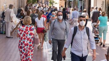 GRAF7305. PALMA DE MALLORCA, 13/07/2020.- Transeúntes se protegen con mascarillas por las calles de Palma de Mallorca, este lunes. La consejera de Salud y Consumo del Gobierno Balear, Patricia Gómez, ha informado sobre la resolución que modifica el decreto que regula las medidas de la "nueva normalidad" en Baleares para fijar la obligatoriedad de la mascarilla, este lunes. Esta semana no se sancionará a quienes no utilicen la mascarilla obligatoria en Baleares "por una cuestión de adaptación y advertencia", ha anunciado Gómez, quien ha precisado que no se multará hasta el 20 de julio. EFE/ Atienza