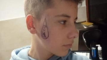 Un niño con un tatuaje en la cara de una lágrima que dentro tiene un surfista con una ola, de una frase de Gazir.