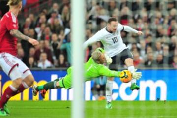 El delantero inglés Wayne Rooney realiza un tiro al  portero Kasper Schmeichel que  intenta bloquearlo durante el partido internacional amistoso de fútbol entre Inglaterra y Dinamarca en el estadio de Wembley en Londres 