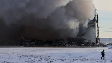 A traffic police officer walks near the burning warehouse of Wildberries online retailer in Saint Petersburg, Russia, January 13, 2024. REUTERS/Anton Vaganov