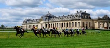 Los corredores se alejan de las Grandes Ecuries Les y se abren camino en la recta al hipódromo de Chantilly