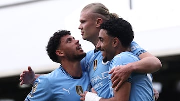 Manchester City's Norwegian striker #09 Erling Haaland (C) celebrates with Manchester City's Portuguese midfielder #27 Matheus Nunes (L) and Manchester City's Egyptian striker #07 Omar Marmoush (R) after scoring their second goal from the penalty spot during the English Premier League football match between Fulham and Manchester City at Craven Cottage in London on May 25, 2025. (Photo by Anne-Christine POUJOULAT / AFP) / RESTRICTED TO EDITORIAL USE. No use with unauthorized audio, video, data, fixture lists, club/league logos or 'live' services. Online in-match use limited to 120 images. An additional 40 images may be used in extra time. No video emulation. Social media in-match use limited to 120 images. An additional 40 images may be used in extra time. No use in betting publications, games or single club/league/player publications. /