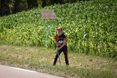 Un espectador con una red improvisada para atrapar los artículos promocionales ("goodies") distribuidos por la caravana publicitaria del Tour de Francia, así como las bidones de los ciclistas.