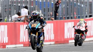 Sky Racing Team VR46 rider Luca Marini of Italy (L) pops a wheelie while receiving a Moto2 class checkered flag ahead of Dynavolt Intact GP rider Thomas Luthi of Switzerland (R) during the Japanese Motorcyle Grand Prix at the Twin Ring Motegi circuit in Motegi, Tochigi prefecture on October 20, 2019. (Photo by Toshifumi KITAMURA / AFP)
