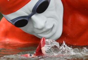 Un nadador de triatlón entrena en el Lago de Hyde Park en Londres, ante una escultura flotante temporal.