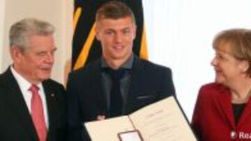 Kroos, recibiendo de manos de Merkel el Laurel de Plata.