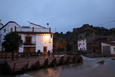 Gregoria, de 84 años, y su esposo Antonio, de 85, miran el Río Seco junto a un puente destruido frente a su casa después de que las fuertes lluvias provocaran inundaciones, en La Hoz de la Vieja, provincia de Teruel, España.