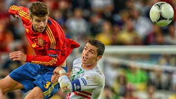 Portuguese forward Cristiano Ronaldo (R) vies with Spanish defender Gerard Pique during the Euro 2012 football championships semi-final match Portugal vs Spain on June 27, 2012 at the Donbass Arena in Donetsk.       AFP PHOTO / PATRICK HERTZOG