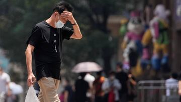 A man wearing face mask reacts on a street amid a heatwave warning, following the coronavirus disease (COVID-19) outbreak in Shanghai, China July 13, 2022. REUTERS/Aly Song