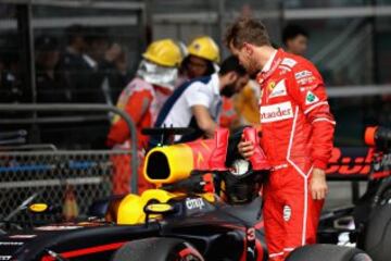 Sebastian Vettel looks at Daniel Ricciardo's car.