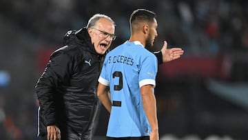 Uruguay's coach Argentine Marcelo Bielsa (L) gives instructions to Uruguay's defender Sebastian Caceres during the 2026 FIFA World Cup South American qualification football match between Uruguay and Brazil at the Centenario Stadium in Montevideo on October 17, 2023. (Photo by Eitan ABRAMOVICH / AFP)