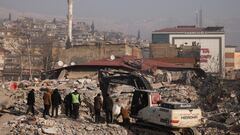 People stand amid rubble and damages, in the aftermath of a deadly earthquake in Kahramanmaras, Turkey February 12, 2023. REUTERS/Stoyan Nenov