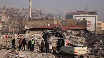 People stand amid rubble and damages, in the aftermath of a deadly earthquake in Kahramanmaras, Turkey February 12, 2023. REUTERS/Stoyan Nenov