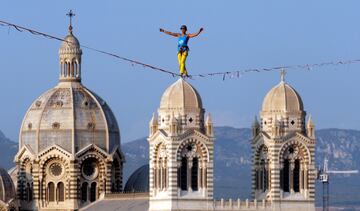 Una funambulista, con la catedral de Santa Mar¨ªa la Mayor de la ciudad de Marsella a su espalda, durante un evento que forma parte de la nominaci¨®n de la ciudad como capital del deporte.