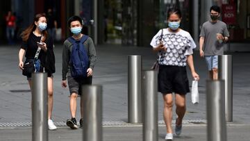 People wearing face masks cross a road amid the coronavirus disease (COVID-19) outbreak in Singapore May 20, 2021. REUTERS/Caroline Chia