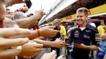 El piloto alem&aacute;n de Red Bull, Sebastian Vettel, firma aut&oacute;grafos al p&uacute;blico.