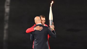 Paris (France), 26/07/2024.- Zinedine Zidane (front) hands the Olympic flame torch to Rafael Nadal (back) at Trocadero during the Opening Ceremony of the Paris 2024 Olympic Games, in Paris, France, 26 July 2024. (Francia) EFE/EPA/Joel Marklund / POOL