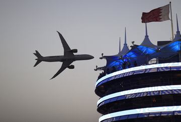 Vista general de la bandera de Bahréin mientras un avión pasa volando por encima del Circuito Internacional. 