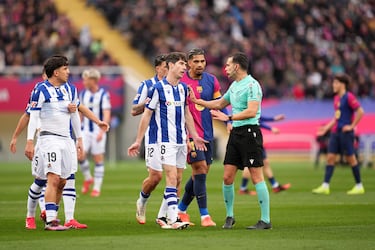 Los jugadores de la Real Sociedad con Elustondo a la cabeza protestan la decisión del árbitro Alejandro Quintero González.
