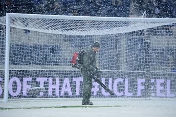 Un operario del club italiano retira la nieve de las lineas del terreno de juego.