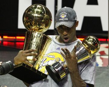 El mítico jugador sostiene en 2009 el trofeo Larry O'Brien de campeón de la NBA y el trofeo MVP de la Final. 
 