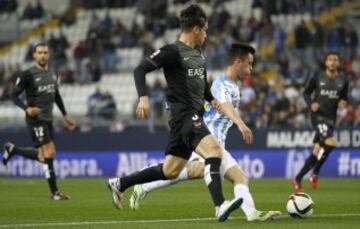 El centrocampista venezolano del Málaga Juan Pablo Añor "Juanpi" (c) escapa del defensa del Levante Toño García, en la jugada finalizada en gol por el venezolano durante el encuentro de la ida de octavos de final de la Copa del Rey que ambos equipos disputan esta noche en el estadio de La Rosaleda.