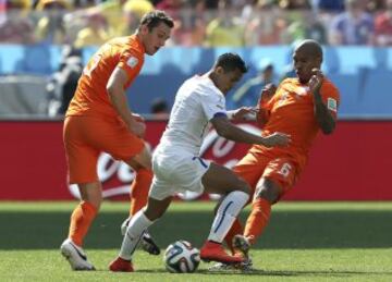 El delantero chileno Alexis Sánchez  con el balón ante los jugadores holandeses Nigel De Jong y Daley Blind.