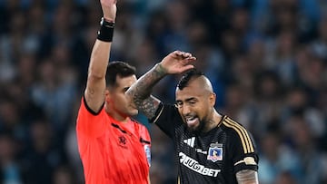 Uruguayan referee Gustavo Tejera books Colo-Colo's midfielder #23 Arturo Vidal during the Copa Libertadores group stage football match between Argentina's Racing Club and Chile's Colo Colo at the Presidente Juan Domingo Peron (El Cilindro) stadium, in Avellaneda, Buenos Aires province, Argentina, on May 14, 2025. (Photo by Luis ROBAYO / AFP)