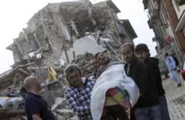 ITA67 AMATRICE (ITALIA) 24/08/2016.- Un hombre herido (c) es rescatado por los equipos de emergencia en Amatrice, en el centro de Italia, hoy, 24 de agosto de 2016. Al menos 38 personas han muerto y decenas se encuentran desaparecidas a causa del terremoto de 6,0 grados de magnitud en la escala abierta de Richter que ha sacudido el centro de Italia en la madrugada de hoy, informó la Protección Civil italiana. EFE/Massimo Percossi