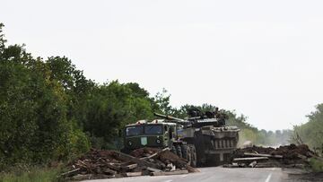 A Ukrainian serviceman gestures on a tank, as it is towed away by a military truck near Bakhmut, as Russia's invasion of Ukraine continues, in Donetsk region, Ukraine August 15, 2022. REUTERS/Nacho Doce