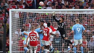 Arsenal's Spanish goalkeeper #22 David Raya (2R) punches the ball clear during the English Premier League football match between Arsenal and Manchester City at The Emirates stadium in London on October 8, 2023. (Photo by Adrian DENNIS / AFP) / RESTRICTED TO EDITORIAL USE. No use with unauthorized audio, video, data, fixture lists, club/league logos or 'live' services. Online in-match use limited to 120 images. An additional 40 images may be used in extra time. No video emulation. Social media in-match use limited to 120 images. An additional 40 images may be used in extra time. No use in betting publications, games or single club/league/player publications. / 