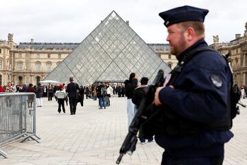 FILE PHOTO: A French CRS riot police officer patrols near the glass Pyramid of the Louvre Museum, after French police arrested suspects in the Louvre heist case, in Paris, France October 27, 2025. REUTERS/Abdul Saboor/File Photo