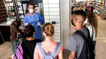 GRAFCAT6393 Hospitalet de Llobregat (BARCELONA) 19/7/2021.- El farmacèutico comunitario y vocal de la Oficina de Farmàcia del Colegio de Farmacèuticos de Barcelona (COFB) Guillermo Bagaría (i), explica a jovenes y monitores de colonias cómo realizar los autotests de antígenos en la farmácia Bagaría Casanova de l´Hospitalet de Llobregat . EFE/Quique Garcia