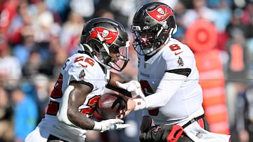 CHARLOTTE, NORTH CAROLINA - JANUARY 07: Baker Mayfield #6 hands off the ball to Chase Edmonds #22 of the Tampa Bay Buccaneers during the first quarter against the Carolina Panthers at Bank of America Stadium on January 07, 2024 in Charlotte, North Carolina.   Grant Halverson/Getty Images/AFP (Photo by GRANT HALVERSON / GETTY IMAGES NORTH AMERICA / Getty Images via AFP)