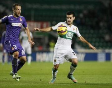 El centrocampista del Elche Víctor Rodríguez pelea un balón con el centrocampista del Espanyol Paco Montañés.