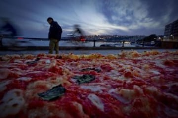 Fotografía facilitada hoy, 19 de mayo de 2016 de una pizza napolitana de dos kilómetros de largo, elaborada para batir el récord del mundo, y colocada a lo largo del paseo marítimo en Nápoles (Italia) ayer. EFE/Ciro Fusco