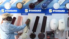 A shopworker cleans dust from fans for sale at an electronics shop after the government eased a nationwide lockdown imposed as a preventive measure against the COVID-19 coronavirus, in Amritsar on May 16, 2020. (Photo by NARINDER NANU / AFP)