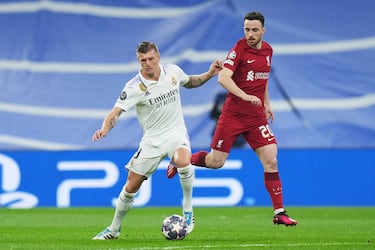 Toni Kroos controla y protege el balón ante Diogo Jota.
