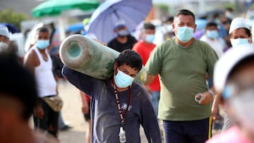 LIMA, PERU - FEBRUARY 27: A man carries an empty oxygen tank to be filled on February 27, 2021 in Villa El Salvador, Lima, Peru. Medical Oxygen to treat COVID-19 patients is scarce and Peru is now importing form Chile to satisfy demand. Relatives make lines overnight to have their cylinders refilled. Peruvian Health Minister has reported over 45,000 victims since the beginning of the pandemic. (Photo by Raul Sifuentes/Getty Images)