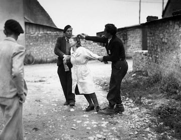 Dos patriotas franceses cortan el cabello a una mujer que fue sorprendida colaborando con los alemanes. La fotografía fue tomada el 10 de agosto de 1944.