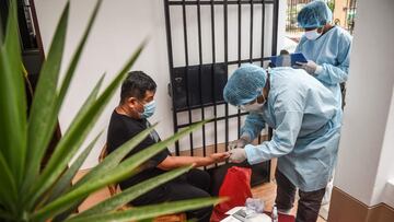 A Peruvian health worker takes a COVID-19 test on a man in his house at El Agustino district in Lima, on January 7, 2021. - Peruvian Government restarted house-to-house COVID-19 testing in patients over 60 years old this Thursday in vulnerable neighborhoo