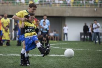 El exfutbolista brasileño Igor ayuda a la niña María Eduarda, durante el evento "Bota do Mundo" o "World Boots" , una cita apadrinada por el jugador del Barcelona y disputada por dieciséis niños de la Asociación de Asistencia de Niños Discapacitados (AACD) que hoy vieron realizado el sueño de compartir balón con algunos de sus ídolos.