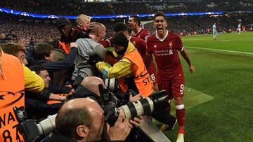 Liverpool's Brazilian midfielder Roberto Firmino (R) reacts after Liverpool's Egyptian midfielder Mohamed Salah scored his team's first goal during the UEFA Champions League second leg quarter-final football match between Manchester City an