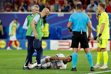 Kylian Mbappé tumbado en el césped tras recibir el impacto que le ocasiona una herida en el tabique nasal.