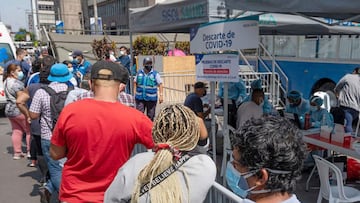 People queue for a free molecular testing and to be vaccinated at a makeshift health center on a street in downtown Lima on January 5, 2022, hours after the Government reported the country is officially facing a third wave of COVID-19 due to the increase of infections after Christmas and New Year festivities. - &quot;During the month of December, COVID-19 cases doubled in Lima and increased by more than 50% nationwide,&quot; said Health Minister Hernando Cevallos at a press conference announcing the measure, also announcing he will propose to the Council of Ministers the adoption of new restrictions. Peru registers 309 cases of the highly contagious omicron variant. (Photo by Cris BOURONCLE / AFP)