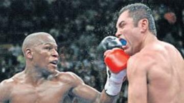 <b>AL MENTÓN. </b>Floyd Mayweather conecta su izquierda en el mentón de Óscar de la Hoya, que está a punto de expulsar el protector bucal debido al fuerte impacto.