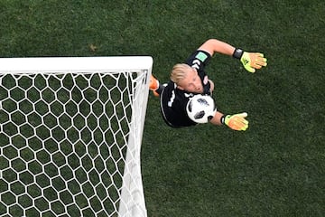 Kasper Schmeichel salta para parar el balón.